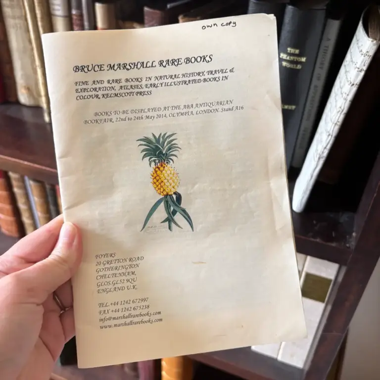 A Bruce Marshall Rare Books list of natural history, travel and exploration books, held in front of bookshelves